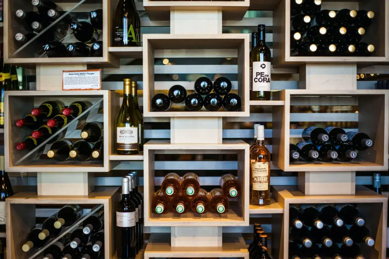 Scaffalatura moderna per vino, con bottiglie disposte in cubi di legno. Ottime idee cantina fai da te per esporre i tuoi vini.