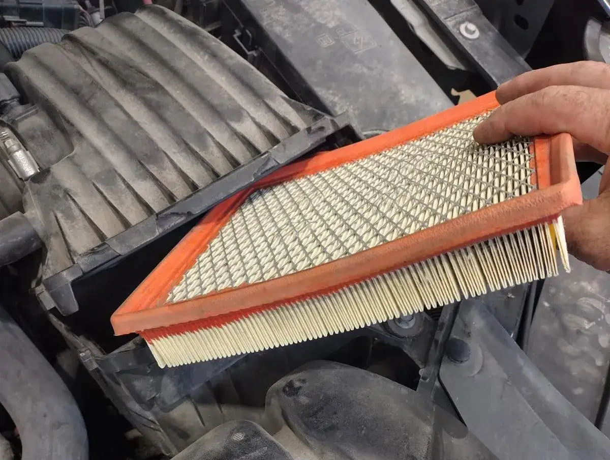 Main tenue un filtre à air de voiture sale. C'est une bonne raison pour changer le filtre à air.