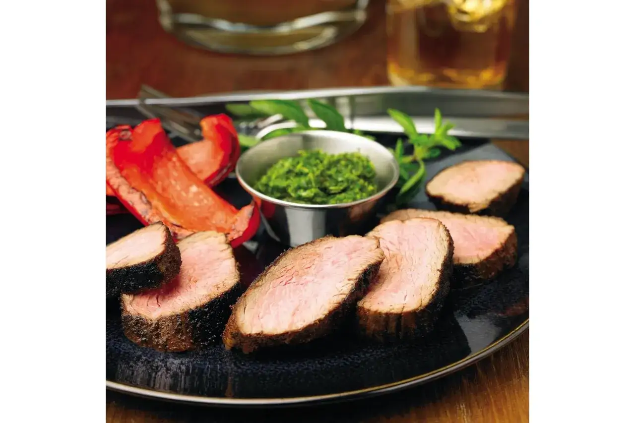 Kawałki soczystej wołowiny z pieczoną papryką i aromatycznym sosem chimichurri.