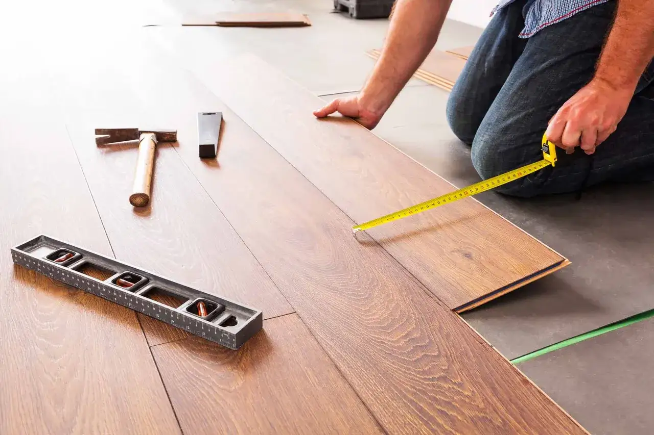 Instalaci&oacute;n de suelo laminado. Herramientas como martillo, nivel y cinta m&eacute;trica ayudan a evitar problemas de instalaci&oacute;n.