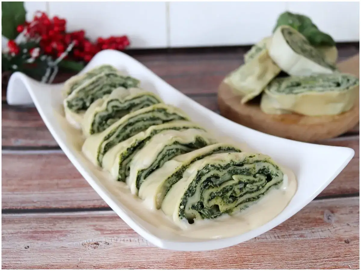 Rotoli di pasta matta con spinaci e formaggio, serviti su un letto di salsa cremosa. Una deliziosa ricetta da provare!