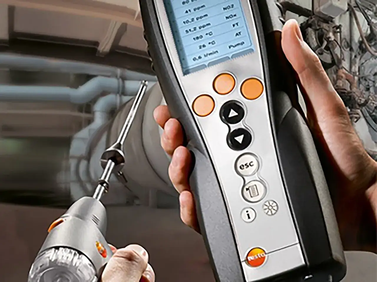 Tecnico esegue prova fumi caldaie con analizzatore. Dati di combustione visibili sul display.