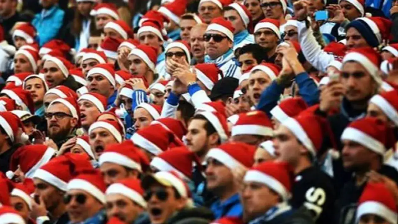 Tłum kibiców w czapkach Mikołaja, świętujących Boxing Day.