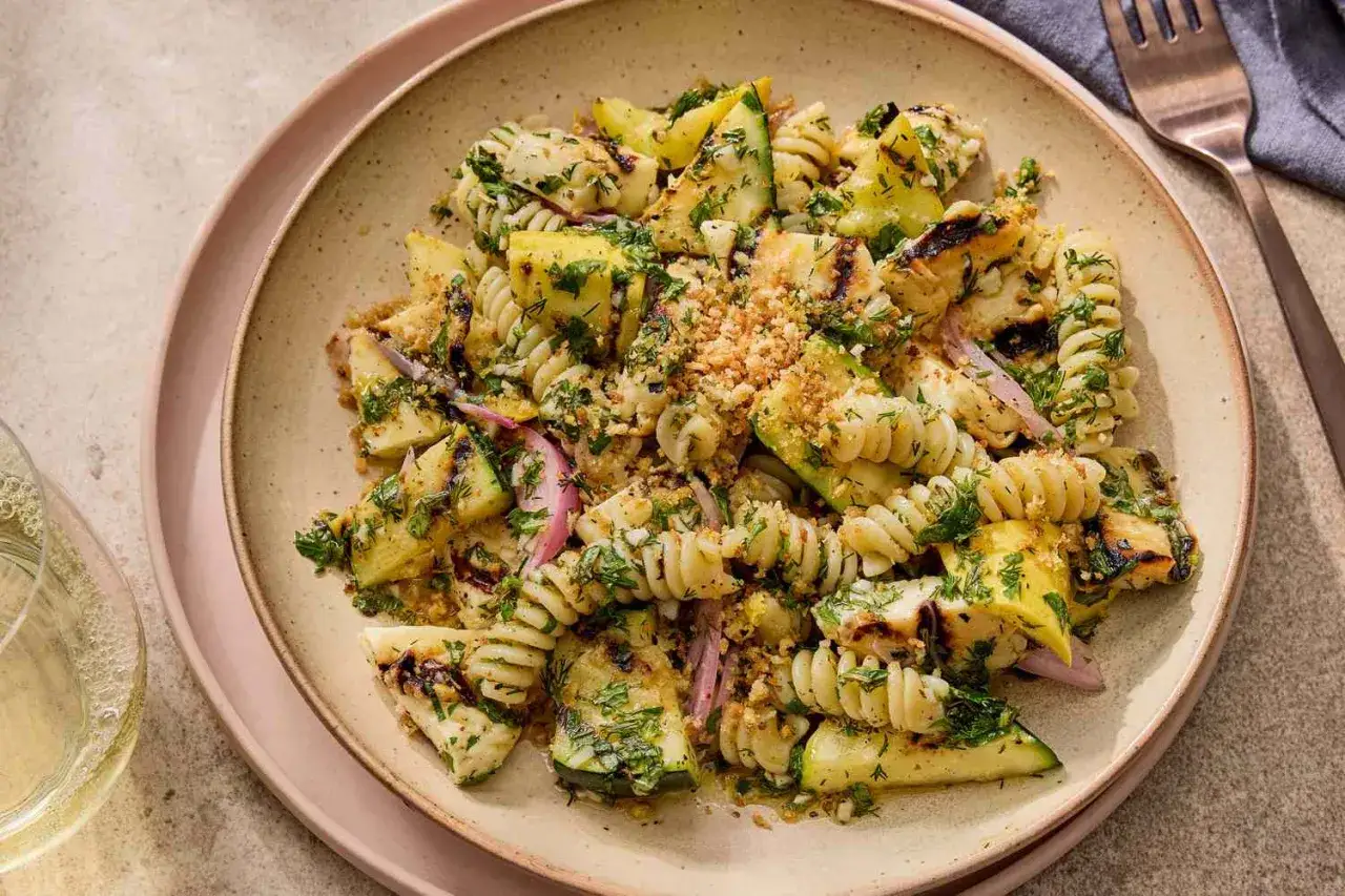 En läcker pastasallad med grillad halloumi, zucchini och rödlök, toppad med färska örter och krispiga krutonger. Perfekt för en somrig lunch!