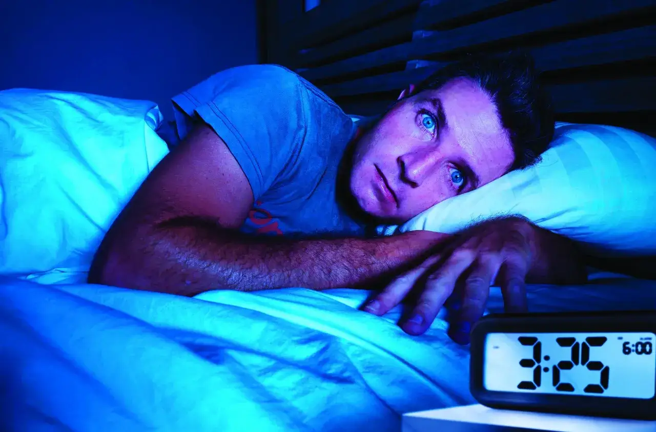 Uomo a letto, occhi spalancati nel buio, il display digitale segna le 3:25. Non riesco a dormire sto impazzendo.