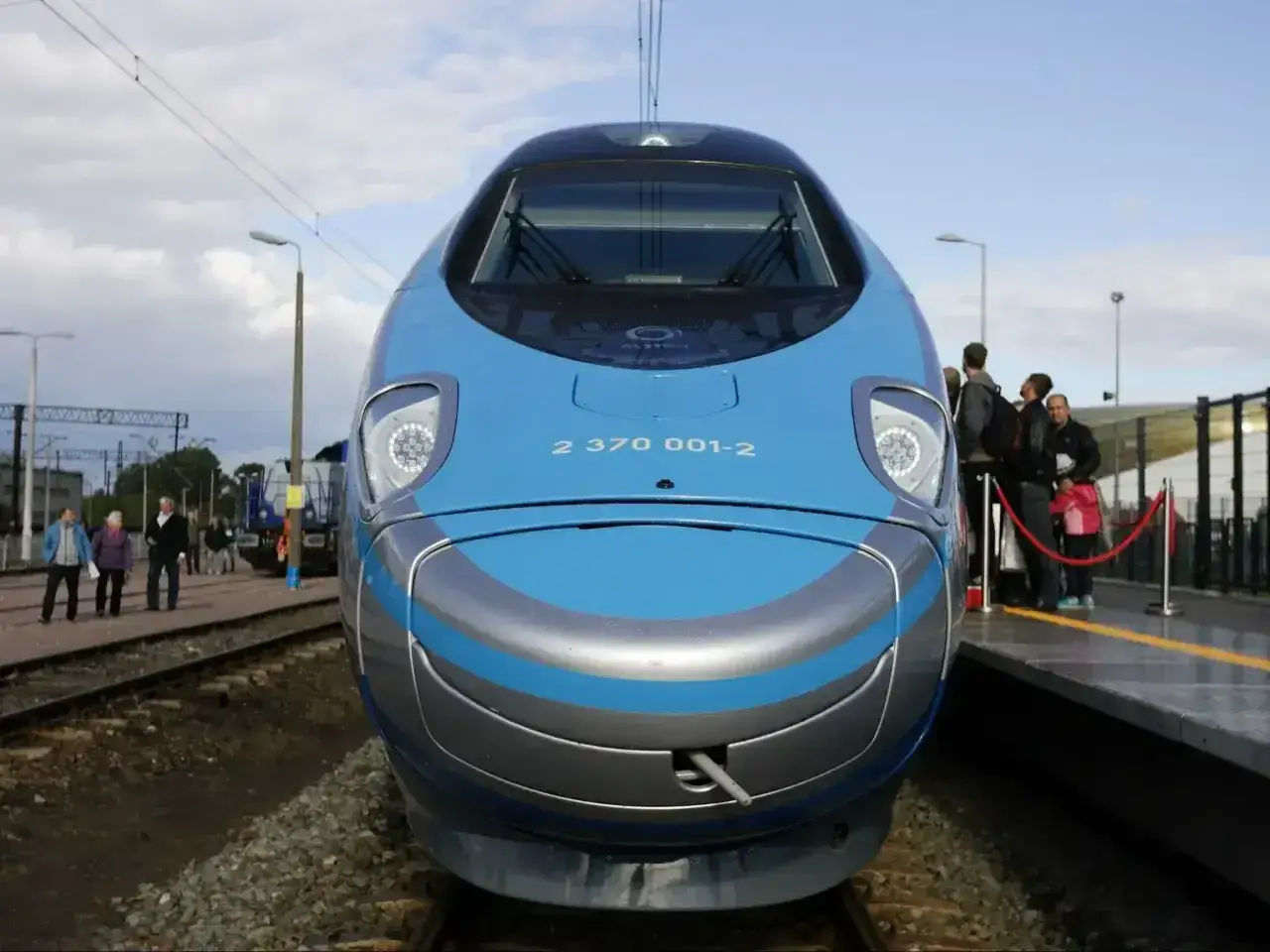 Pendolino Kraków Gdańsk cena - nowoczesny pociąg na peronie, pasażerowie czekają na podróż.