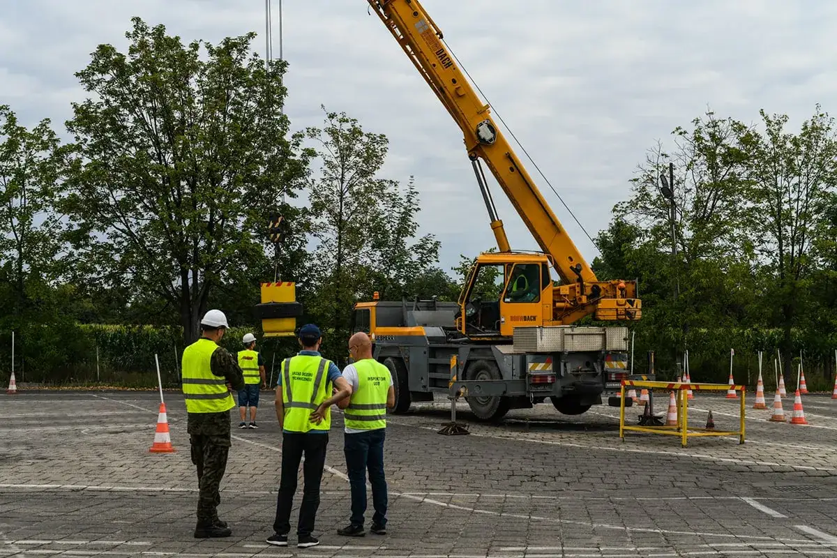 Szkolenie z uprawnień HDS: kierowcy w kamizelkach obserwują pracę dźwigu.