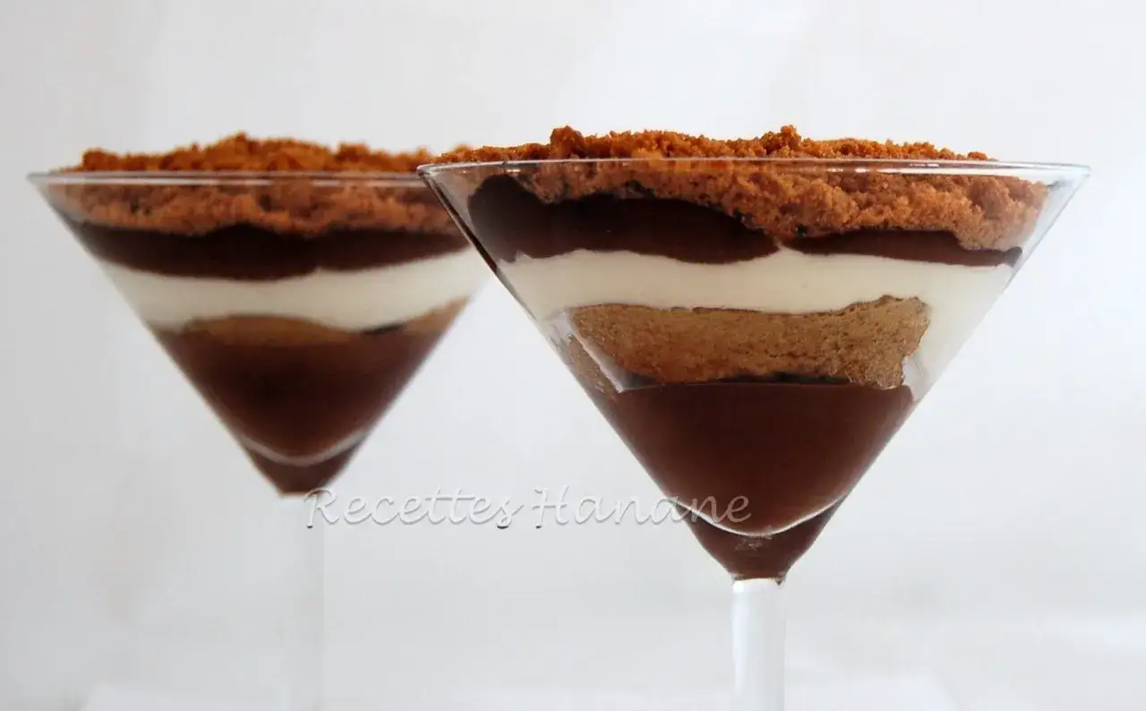 Deux coupes de tiramisu sans oeuf, superposant biscuits, crème et chocolat, garnies de miettes de spéculoos.