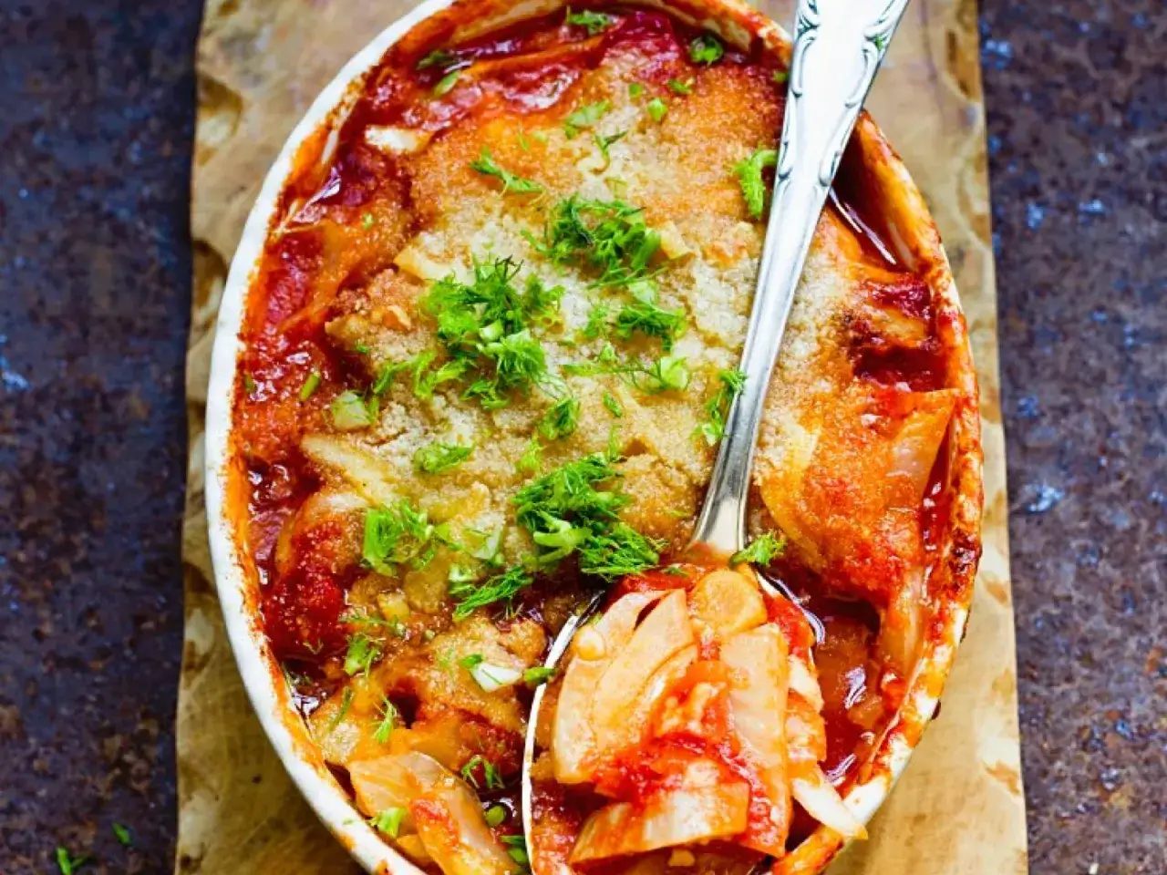 Herzhaftes Fischgericht mit Fenchel und Tomaten aus dem Ofen, garniert mit frischen Kr&auml;utern.