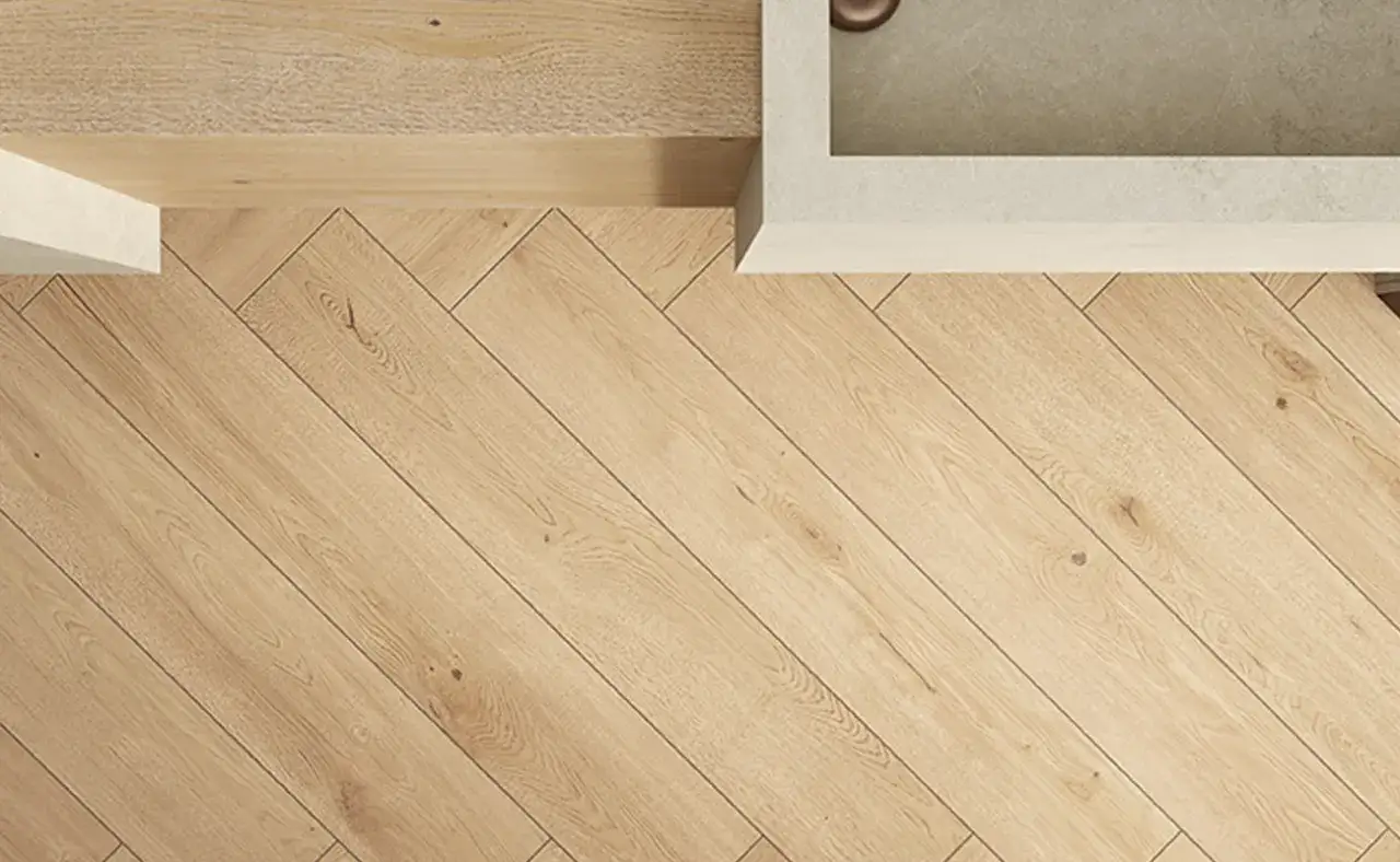 Pavimento in legno con posa a correre a spina di pesce, vicino a un piano in pietra.