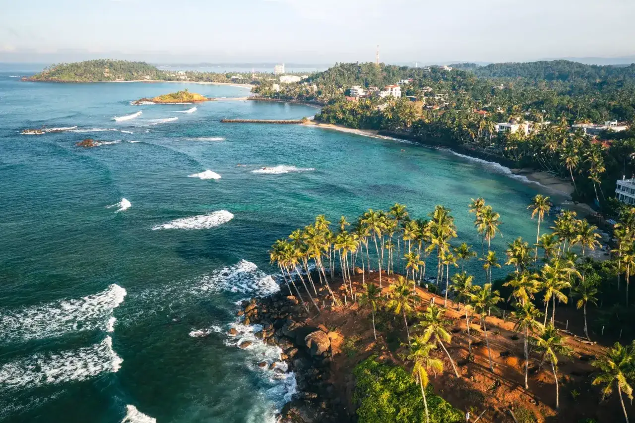 Traumhafte Küste Sri Lankas mit Palmen und türkisfarbenem Meer. Perfekt für Ihre Sri Lanka Reisezeit!
