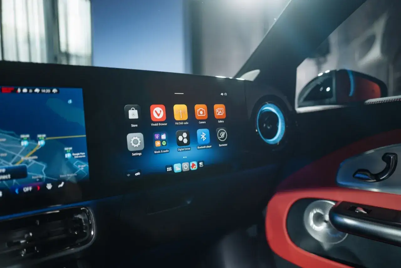 Interior de un coche con pantalla táctil mostrando apps como navegador y música. El sistema de infoentretenimiento del Denza Z9 GT ofrece una experiencia moderna.