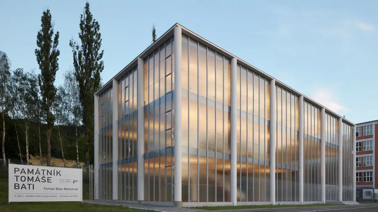 Das Tomas Bata Memorial in Zl&iacute;n, Tschechien, mit seiner Glasfassade, die das Abendlicht reflektiert.