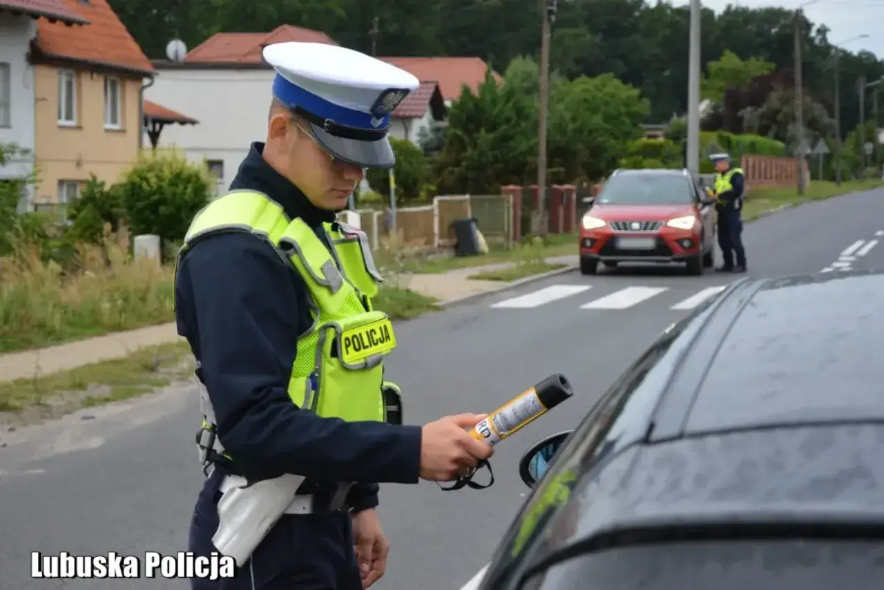 Policjant kontroluje kierowcę, przypominając, że nie można pić piwa w aucie.