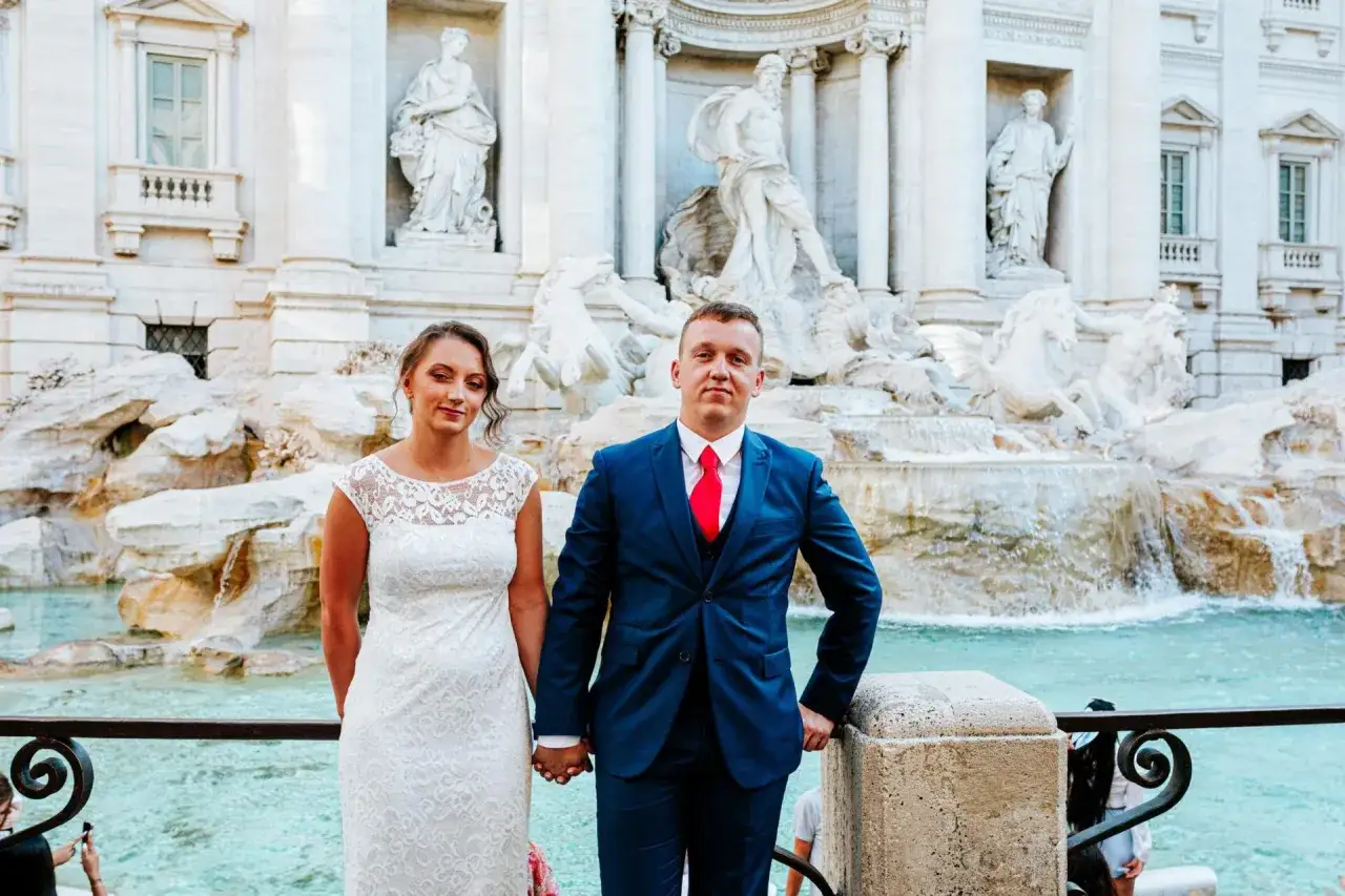 Para młoda pozuje przy Fontannie di Trevi, celebrując sw&oacute;j ślub w Rzymie.