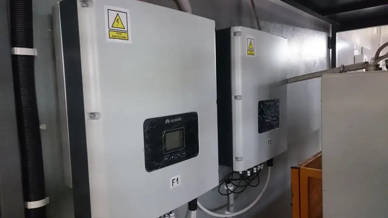 Dwa falowniki Huawei 20kW zamontowane na ścianie. Jeden z nich ma widoczny wyświetlacz i oznaczenie F1.