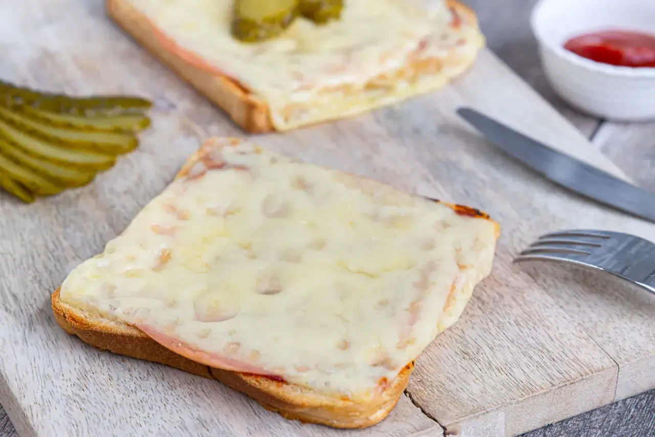 Zwei überbackene Scheiben Brot mit Schinken und Käse, dazu Gewürzgurken. Eine Karlsbader Schnitte, perfekt für den kleinen Hunger.