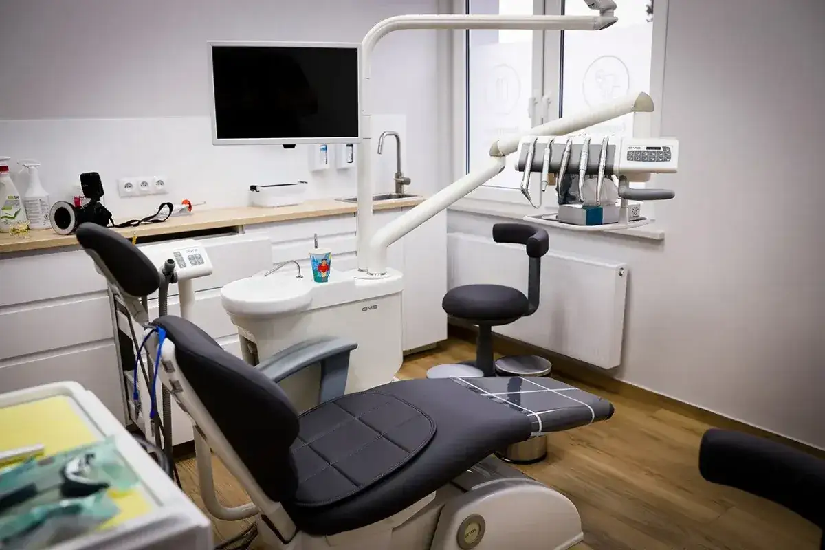 Nowoczesny gabinet stomatologiczny z fotelem dentystycznym i sprzętem.