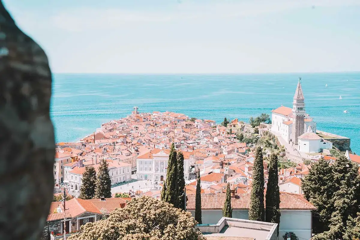 Piran: malerische Küstenstadt mit roten Dächern und Kirche am Meer. Entdecke Piran Geheimtipps für deinen Urlaub!