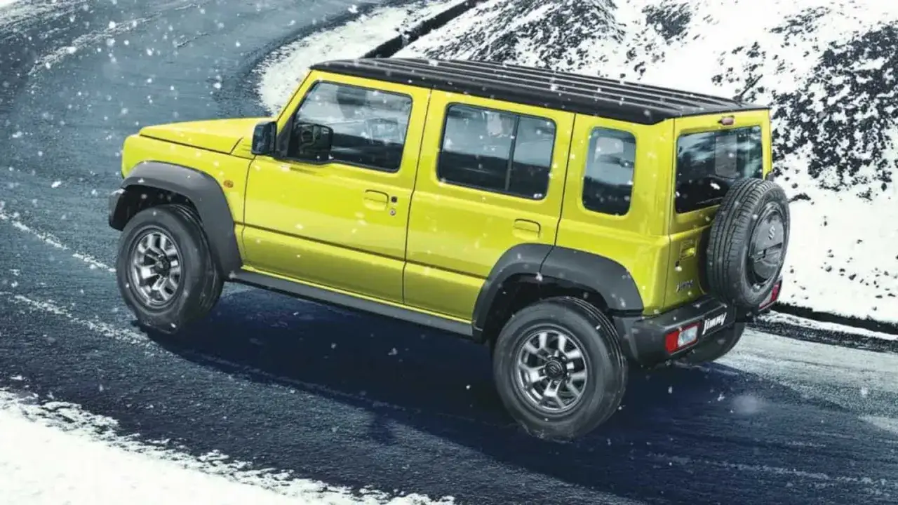 Żółty Suzuki Jimny 5-drzwiowy na śnieżnej drodze. Sprawdź suzuki jimny 5-drzwiowy cena i możliwości terenowe.