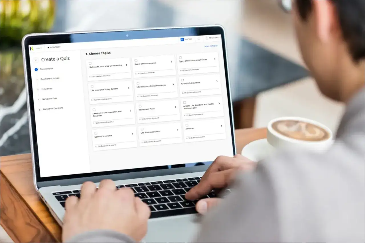 Un étudiant prépare son bts assurance à distance en choisissant des sujets sur son ordinateur portable, une tasse de café à proximité.