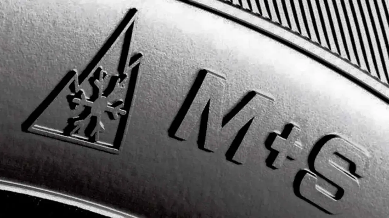 Nahaufnahme eines Reifens mit Schneeflockensymbol und der Kennzeichnung M+S f&uuml;r Matsch und Schnee.