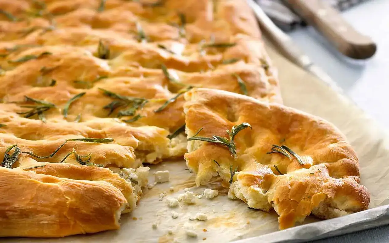 En gyllene, nybakad focaccia med rosmarin och ost. Perfekt f&ouml;r ett enkelt focaccia recept.