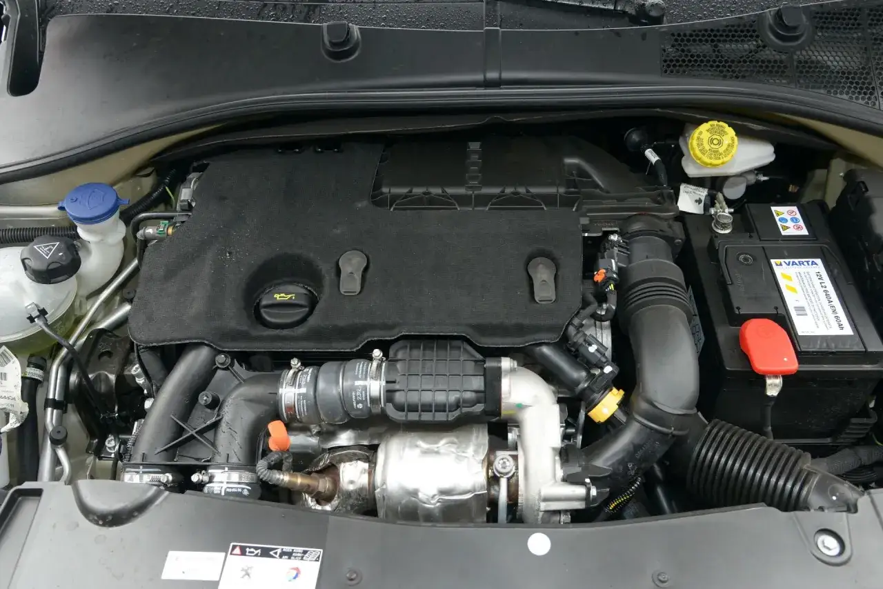 Silnik Peugeot 301 z widocznym akumulatorem Varta, płynem chłodniczym i innymi elementami.