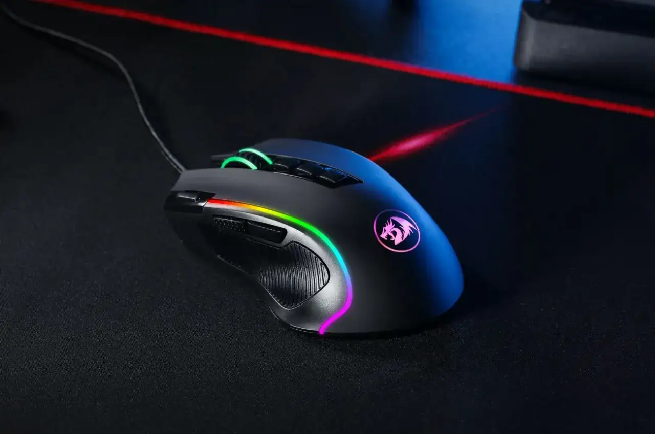 Czarna, podświetlana RGB myszka gamingowa z logo smoka na obudowie, leżąca na czarnej podkładce. Idealna do gier.