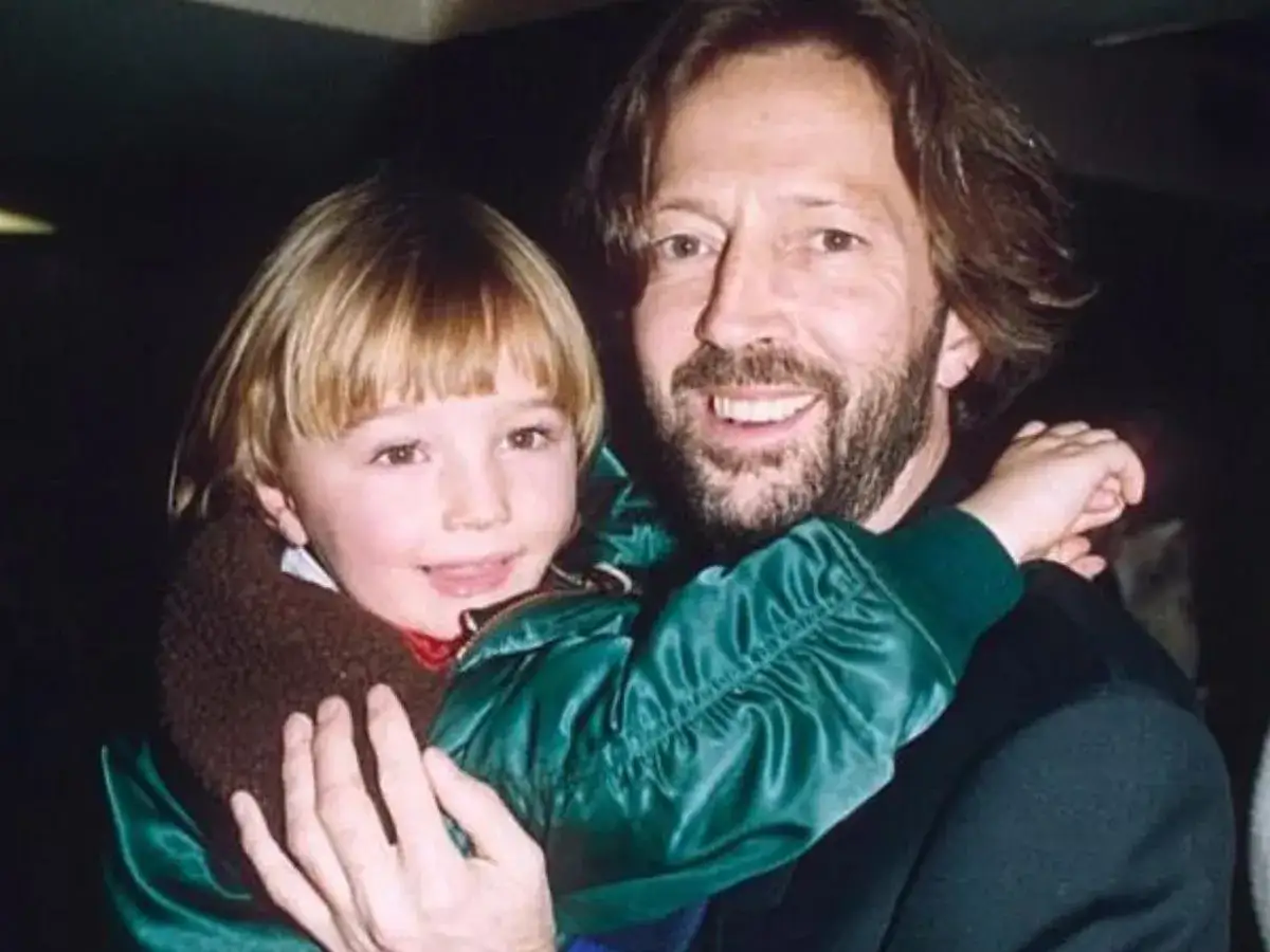Uśmiechnięty Eric Clapton trzyma swojego syna.