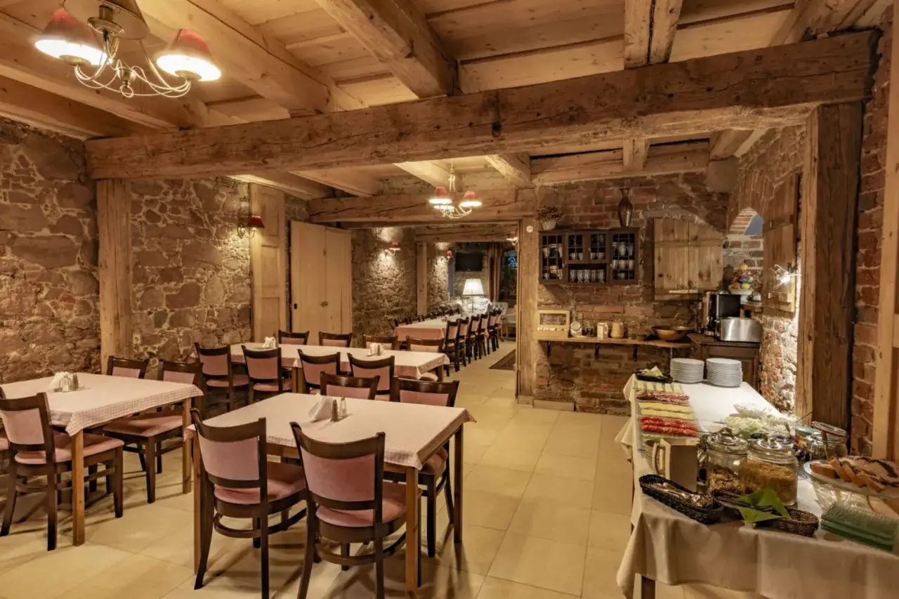 Przytulna restauracja w stylu rustykalnym, z kamiennymi ścianami i drewnianymi belkami. Idealne miejsce na posiłek w twierdzy Srebrna Góra.
