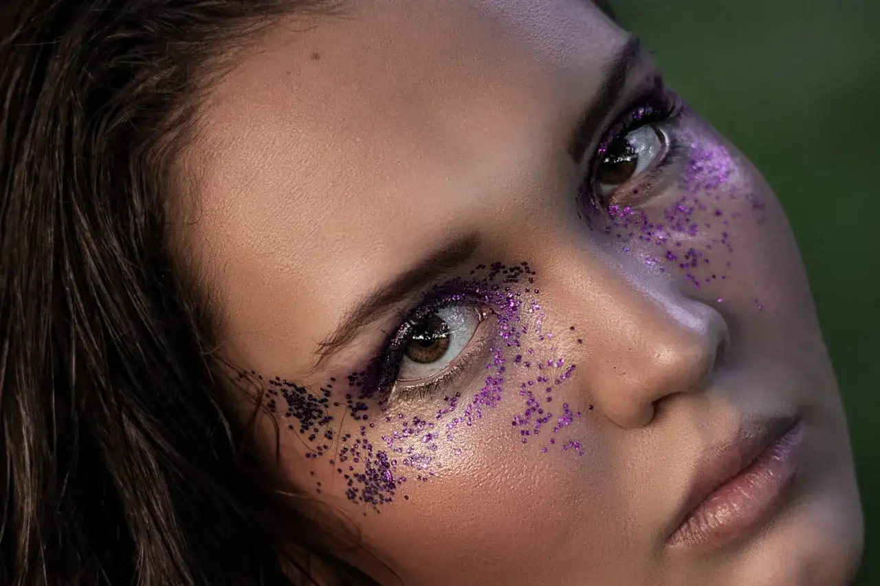 Un maquillage yeux Noël facile avec des paillettes violettes scintillantes. Un regard festif et glamour.