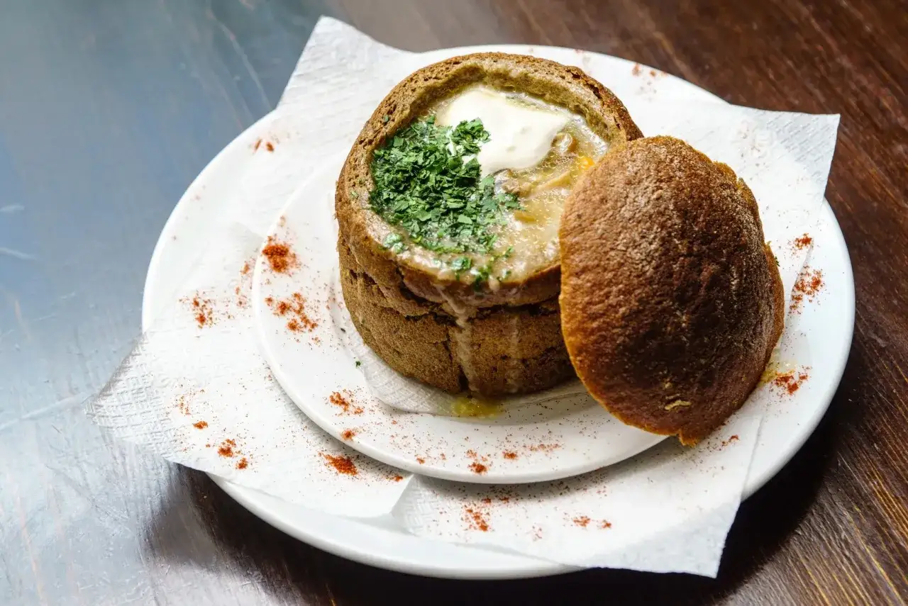 Un d&eacute;licieux plat de soupe dans un pain rond, pr&ecirc;t &agrave; faire lever la p&acirc;te au four. Garniture de persil frais et de cr&egrave;me.