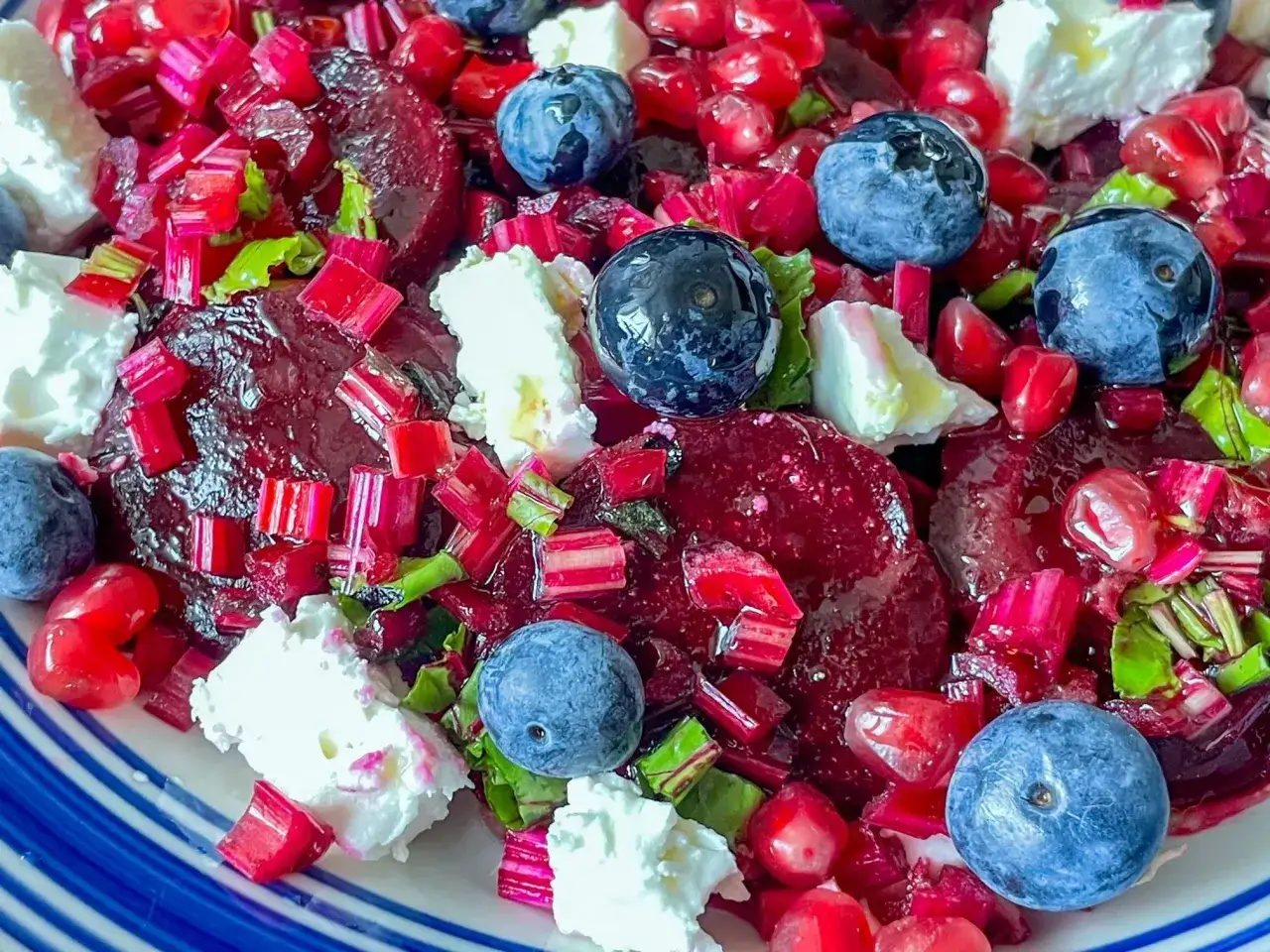 Kolorowa sałatka z burakiem, jagodami, granatem i serem feta. Pyszne połączenie smak&oacute;w i kolor&oacute;w.