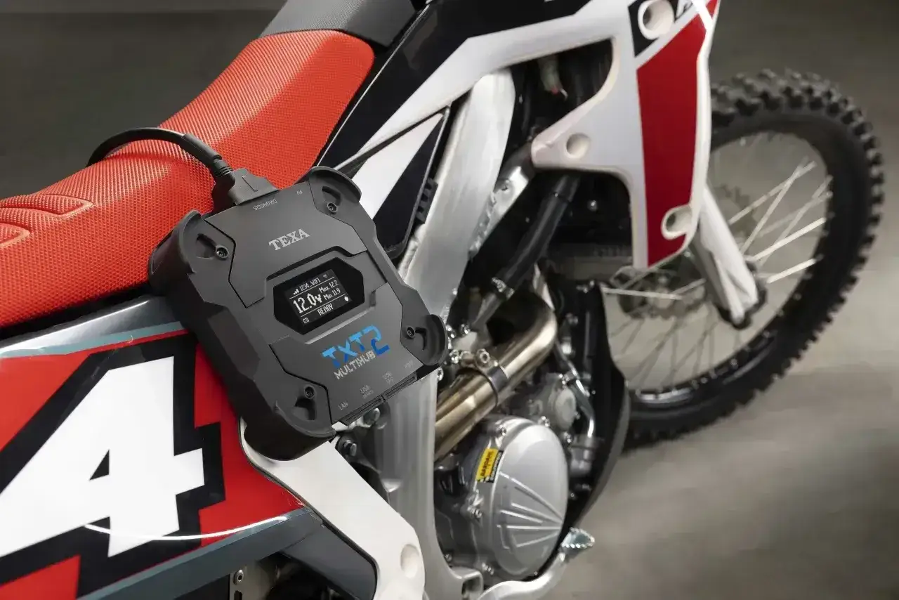 Urządzenie diagnostyczne TEXA TXT2 podłączone do motocykla, gotowe do sprawdzenia kontroli trakcji i innych parametrów.