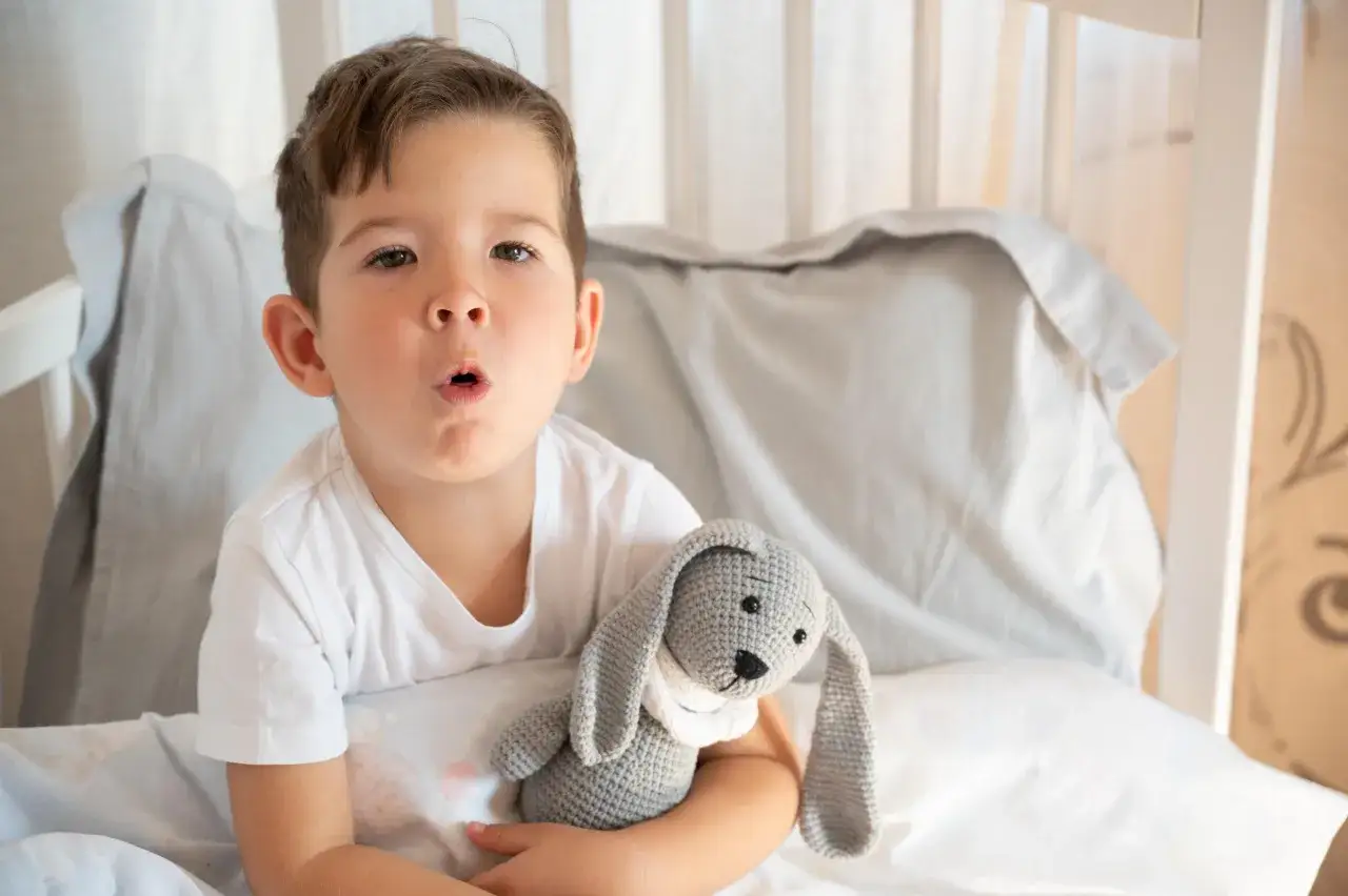 Ni&ntilde;o con juguete de conejo, parece tener tos perruna.