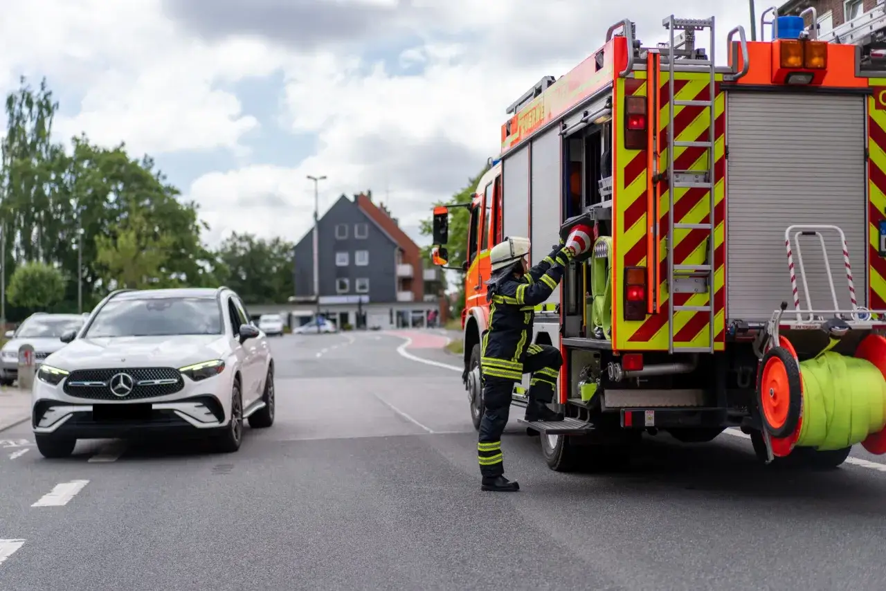 Feuerwehrmann steigt auf LKW, bereit für den Einsatz. Die Gefahrenmatrix der Feuerwehr wird hier sichtbar, wenn sie schnell reagieren müssen.