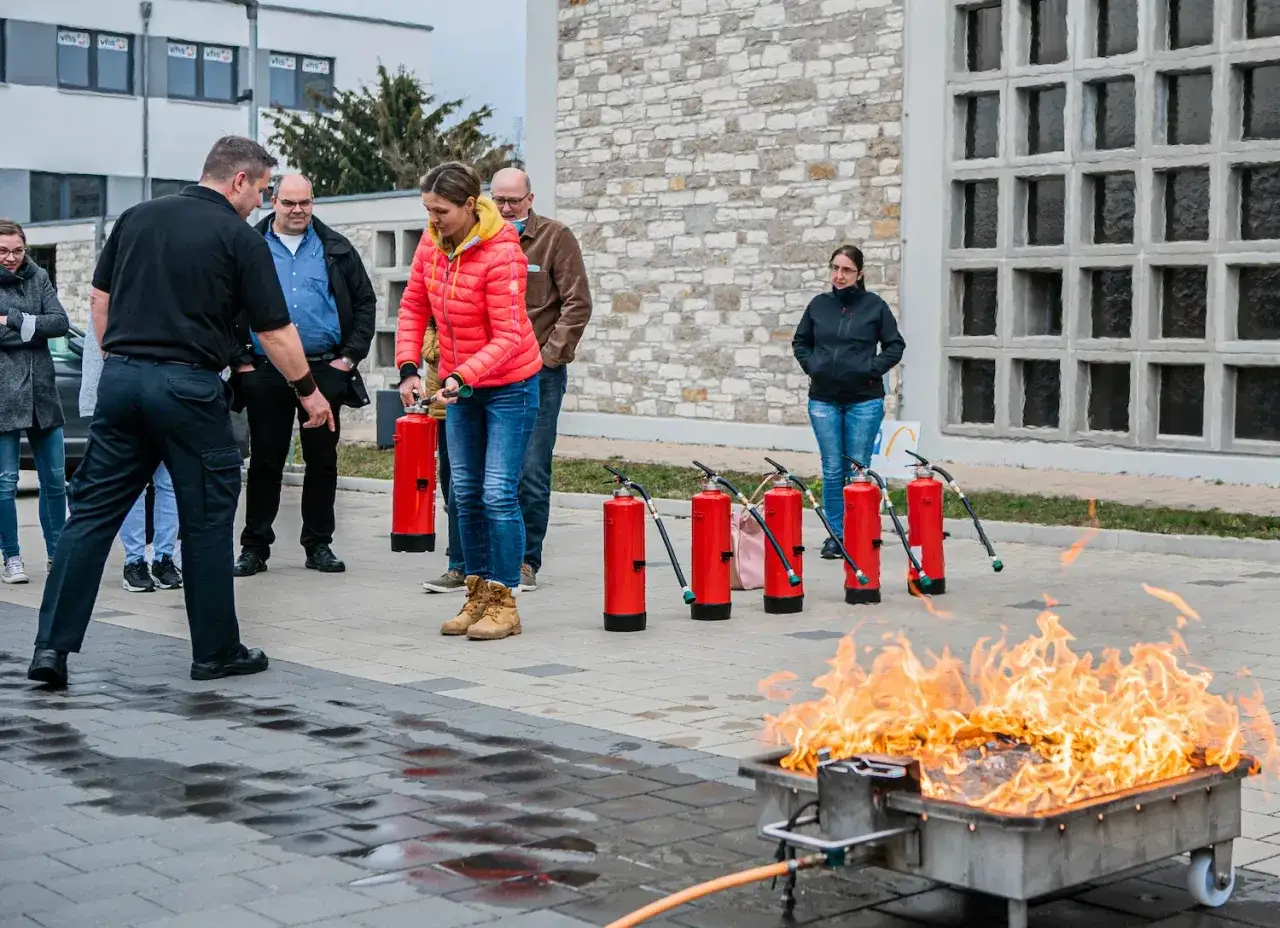 Brandschutzhelfer &uuml;ben den Umgang mit Feuerl&ouml;schern. Die Anzahl der bereitgestellten Feuerl&ouml;scher ist f&uuml;r die Schulung ausreichend.