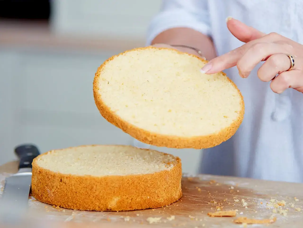 Ein goldbrauner Tortenboden wird angehoben, bereit für das nächste Schicht. Ein perfektes Tortenboden Rezept für jeden Anlass.