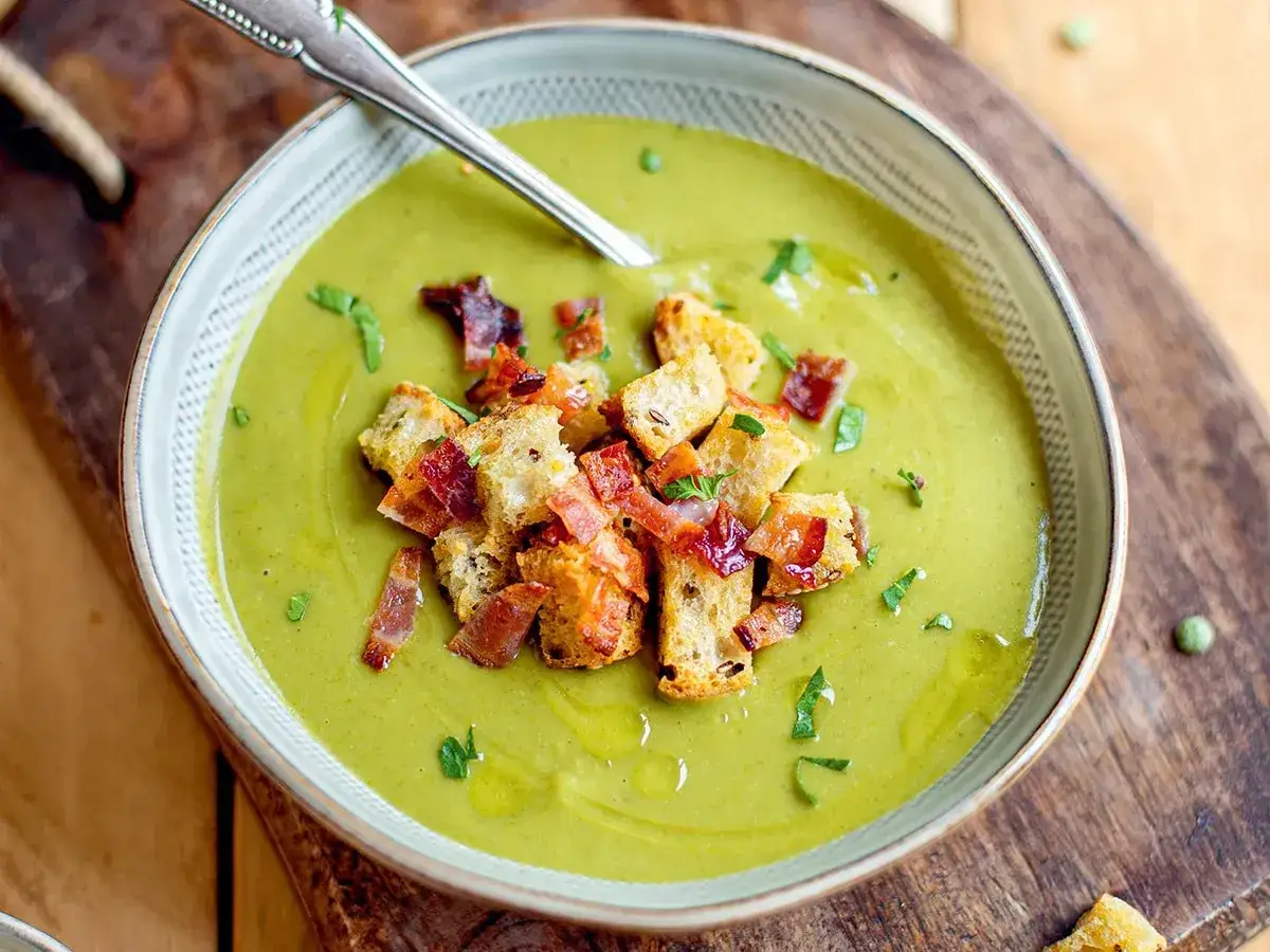 Un bol de soupe de pois cassés onctueuse, garnie de croûtons dorés et de lardons croustillants. Un délice réconfortant.