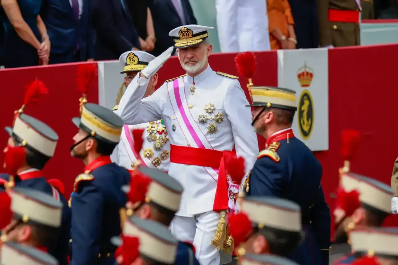 El Rey Felipe VI, condecorado, saluda en un desfile militar, luciendo los títulos del Rey de España.