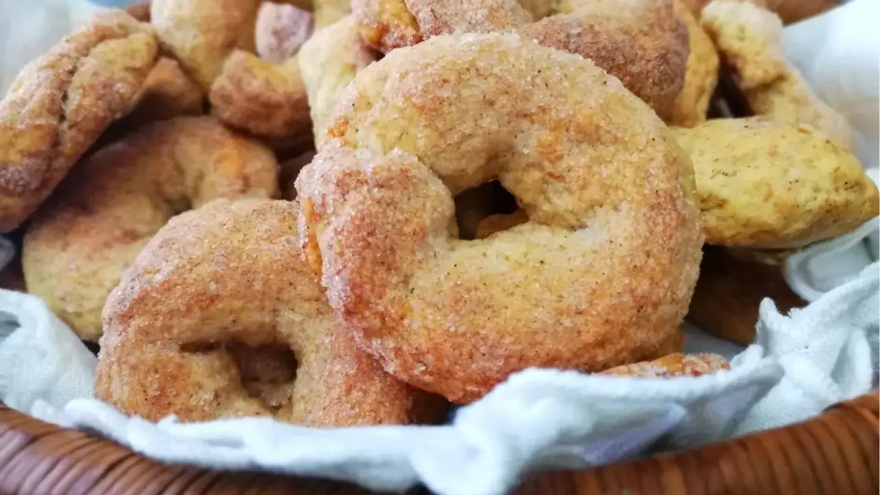 Ciambelline al vino ricetta originale, dorate e zuccherate, in un cesto di vimini.