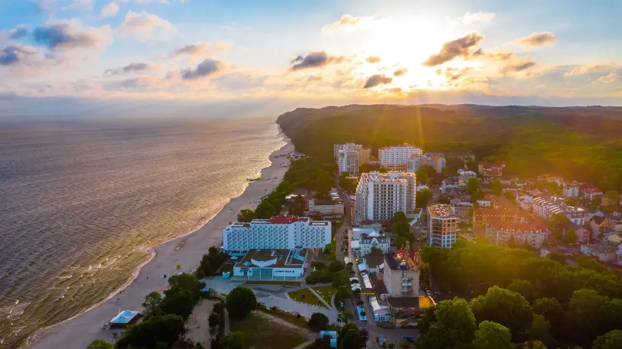 Zachód słońca nad polskim morzem, idealne miejsce, gdzie do Słowenii nad morze, z widokiem na plażę i hotele.