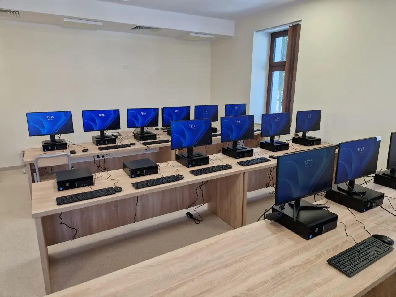 Sala komputerowa z rzędami stanowisk, gotowa na przyszłego **technika informatyka**.