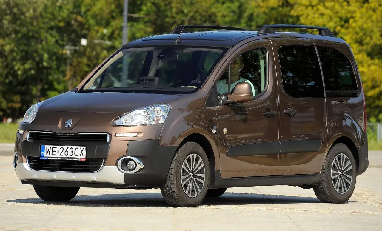 Brązowe, duże auto rodzinne Peugeot z relingami dachowymi i przyciemnianymi szybami, gotowe na wakacyjne wyjazdy.