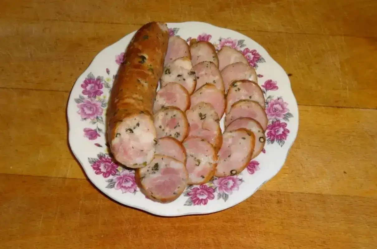 Kiełbasa drwala przepis: pokrojona na talerzu z kwiatowym wzorem, gotowa do podania.