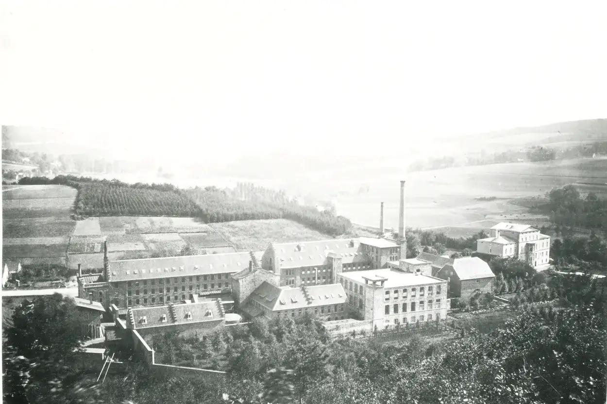Industriekomplex in Engelskirchen Altstadt mit rauchenden Schornsteinen und umliegenden Feldern.