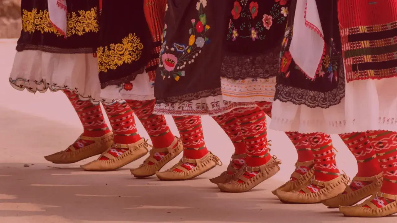 Nogi w tradycyjnych strojach, czerwone, wzorzyste skarpety i mokasyny, gotowe do mazurka tańca.