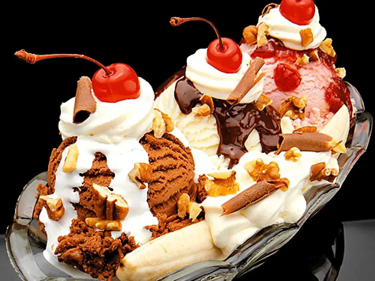 En läcker banana split med tre kulor glass, vispgrädde, körsbär, nötter och choklad.
