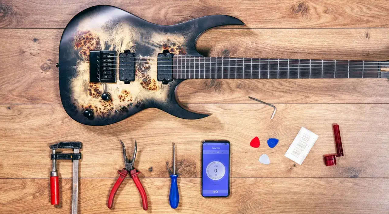Gitarre mit Werkzeug und Handy-App zum Einstellen der Saitenlage.